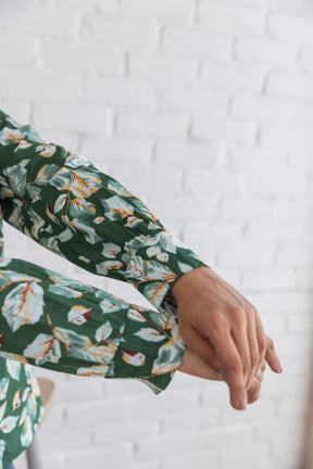 Green cotton shirt top with floral design and rolled sleeves.