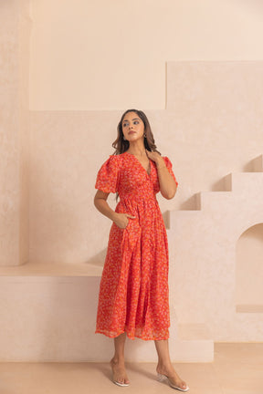 Stylish woman in red chiffon slit maxi dress on neutral background.