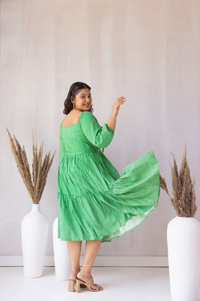 Model twirling in green SHAMROCK MAXI dress with tiered design.