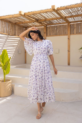 Elegant white chiffon maxi dress with floral print and flowing sleeves.
