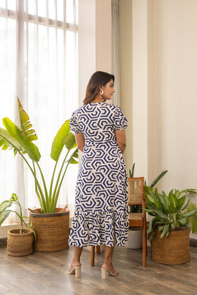 Elegant woman in patterned nursing maxi dress with ruffled hem.