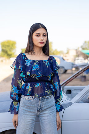 Berry blue floral top with ruffled sleeves and casual jeans.