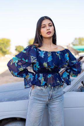 Model wearing Berry Blue Floral Top with bell sleeves.