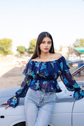 Model wearing BERRY BLUE FLORAL TOP with blue floral design.