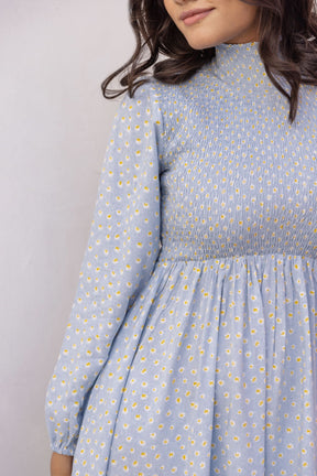 Cotton smocked midi dress in blue with floral patterns.