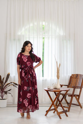 Elegant woman in floral wine co-ord dress indoors with natural light.