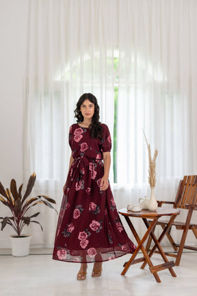 Elegant woman in wine floral co-ord dress, indoor setting.