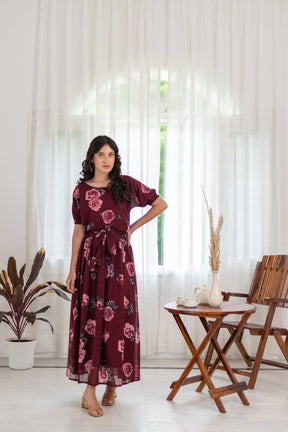 Woman wearing wine floral co-ord dress in a bright indoor setting.