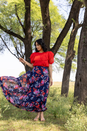 Stylish red and blue co-ord outfit in natural setting.