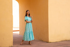 Model wearing Sea Blue Floral Maxi dress in sunny setting.