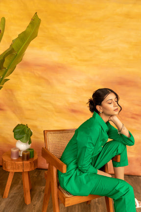 Stylish woman in green Shamrock co-ord set against vibrant background.