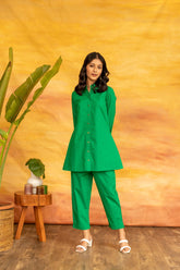 Green SHAMROCK CO-ORD SET styled with accessories and plants.