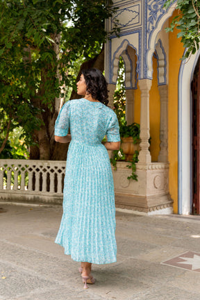 Sky blue pleated maxi dress with floral pattern, elegant summer style.