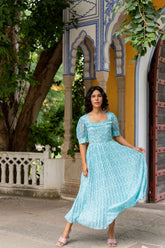 Elegant sky blue pleated maxi dress styled outdoors.